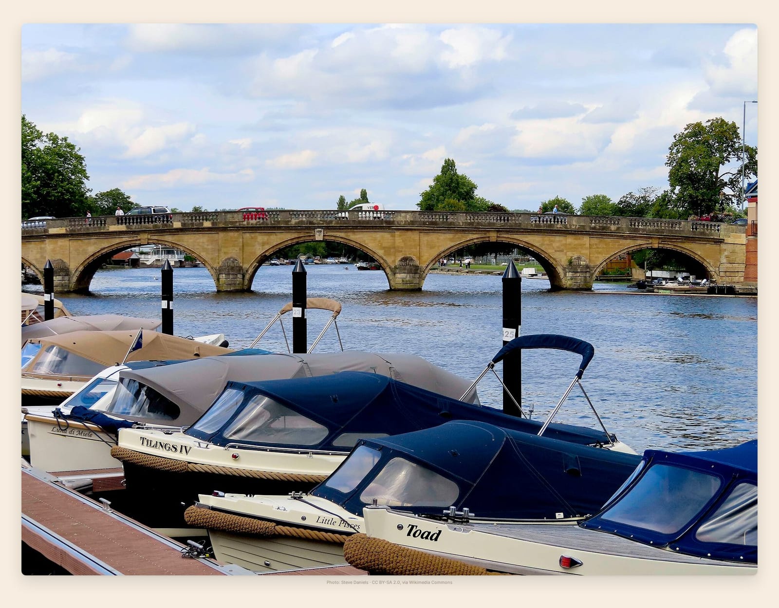 Cabin cruisers moored on the Thames beneath Henley's stone-arched bridge