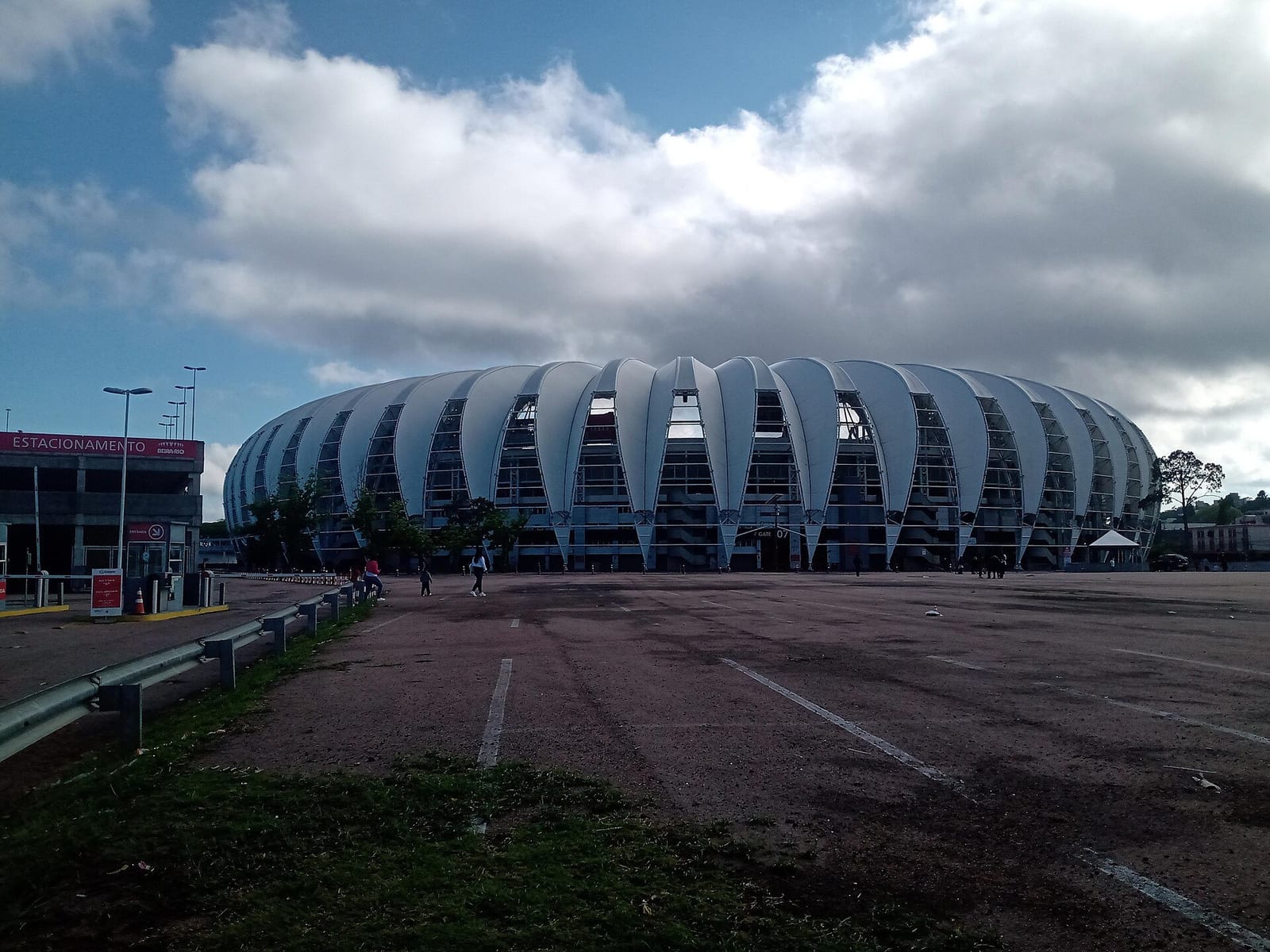 Beira-Rio's ribbed white roof curves upward like overlapping petals against a heavy, cloud-piled sky