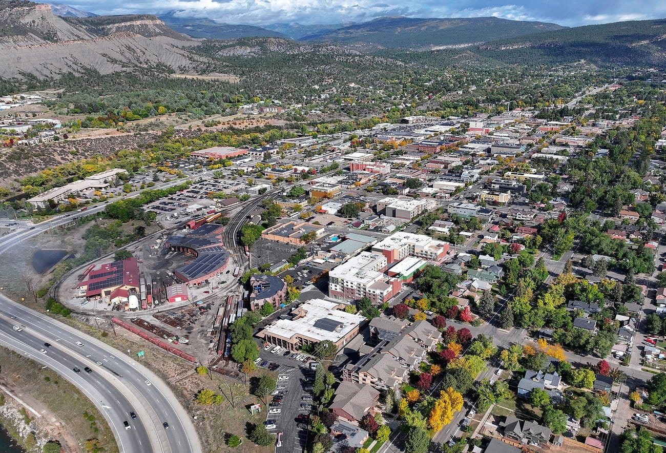 Durango, Colorado from the air in autumn, the narrow-gauge railroad yard beside downtown and dry hills behind