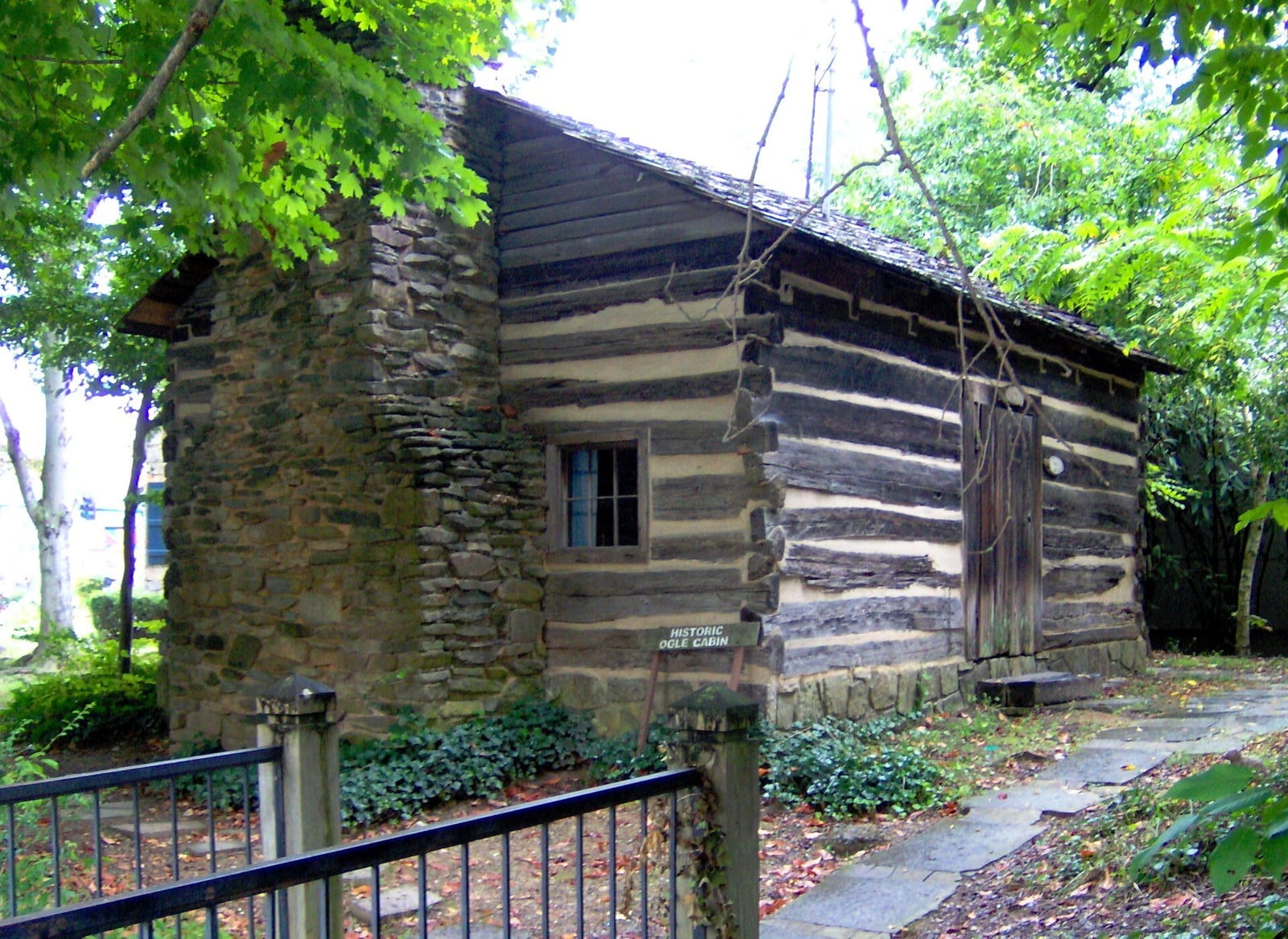 A historic log cabin tucked among fall trees in the Great Smoky Mountains.