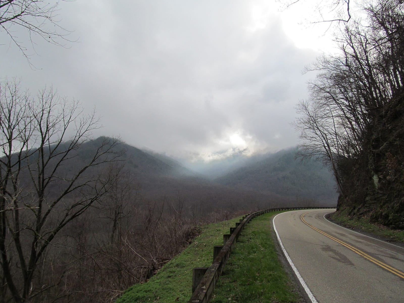 A quiet two lane road winding through forested ridgelines in Great Smoky Mountains National Park.