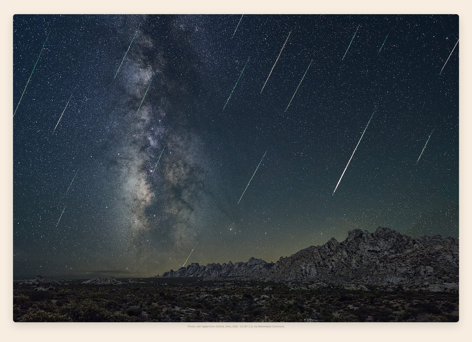 Dozens of Perseid meteors streak past the Milky Way above a desert mountain ridge