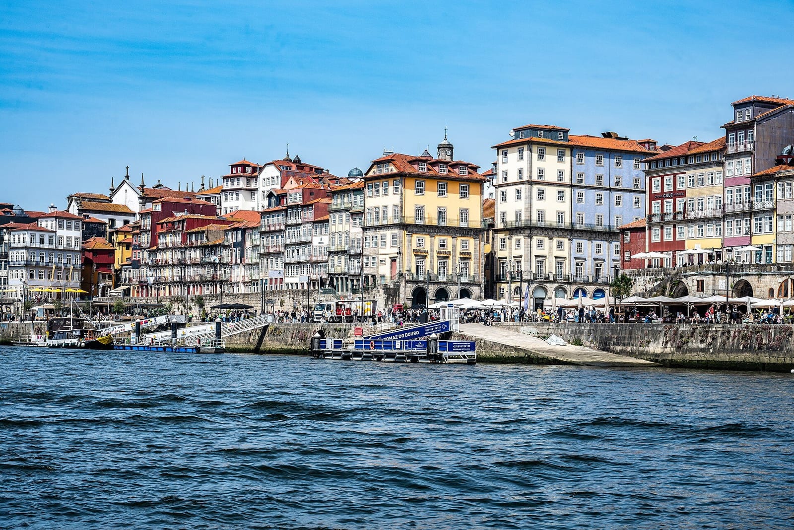 Porto's colourful Ribeira riverfront houses rise above the Douro on a clear afternoon
